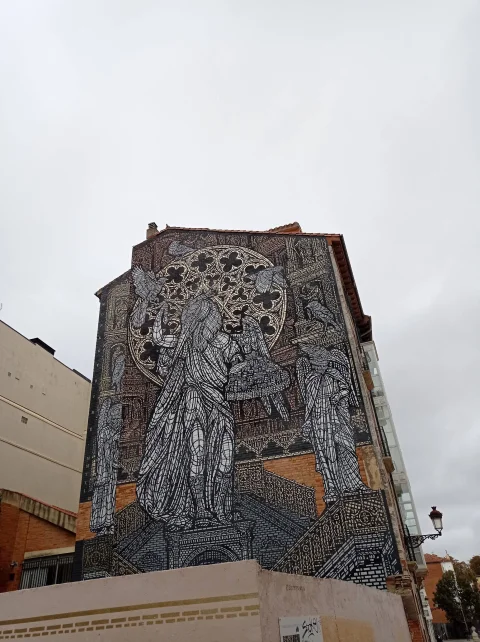 Fotografía desde abajo al mural artísticamente elaborado con figuras estilizadas e influencias góticas