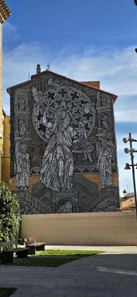 Gran mural que representa figuras alegóricas de aves, elementos góticos y rosetones en blanco y negro