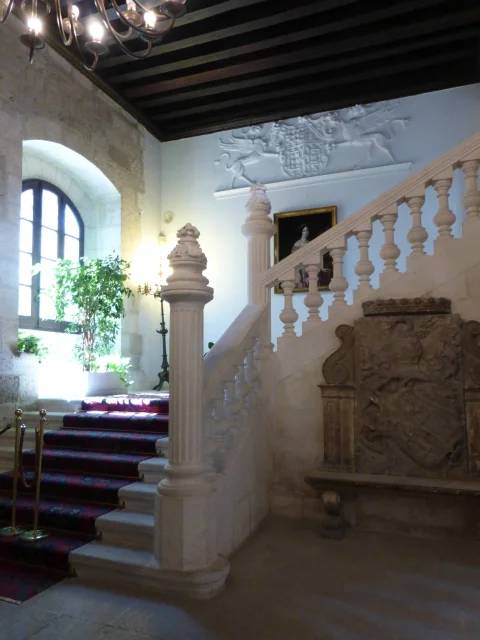 Escalera principal de piedra con alfombra roja