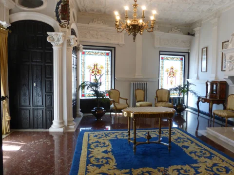 Gran salón de recepción con vidrieras y lámpara de araña