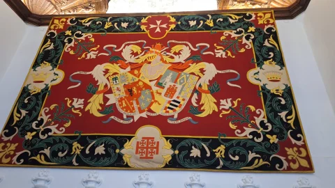 Tapiz heráldico con escudo de armas bordado