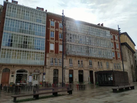 Fachadas residenciales castellanas de ladrillo y piedra con miradores corridos de madera blanca y terrazas