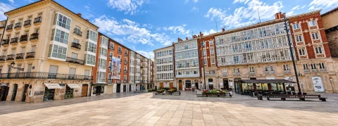 Panorámica luminosa de la plaza peatonal rodeada por edificios con miradores acristalados típicos de Burgos