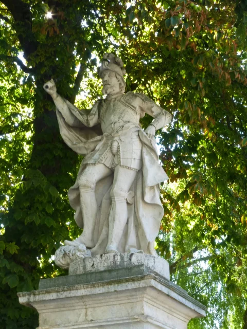 "Estatua de piedra caliza de Fernán González con armadura y capa sobre pedestal