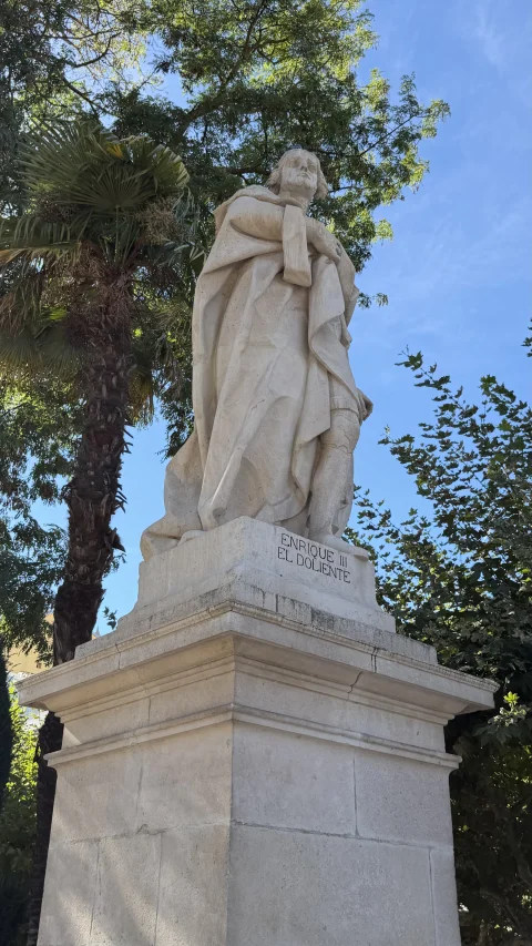 Estatua de piedra blanca del rey Enrique III con ropajes de época sobre un pedestal alto