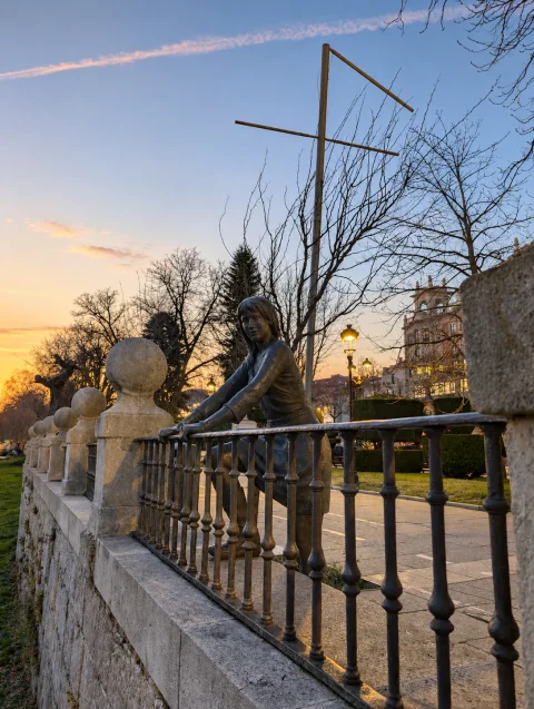 Perspectiva de La Mujer mirando al río Arlanzón al ponerse el sol entre el pretil con esferas de piedra y farolas