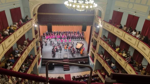 Concierto de orquesta y coro en el escenario del Teatro Principal visto desde los palcos superiores