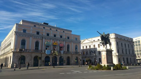 Decoración festiva de máscaras y coronas en los balcones del Teatro Principal junto a la estatua del Cid