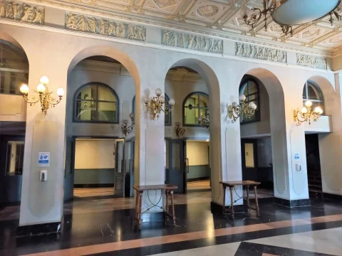 Galería interior de arcos de medio punto del vestíbulo con apliques clásicos y frisos ornamentados