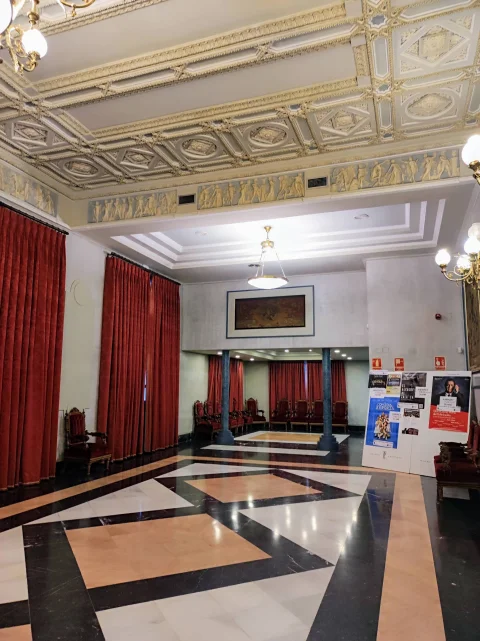 Vestíbulo noble del Teatro Principal con pavimento geométrico de mármol y techo de casetones ornamentados