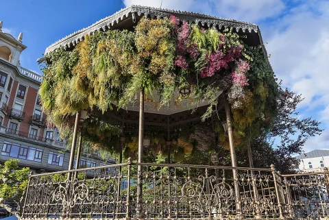 Barandilla de hierro forjado y cornisa del quiosco de música ornamentada con frondosas composiciones florales