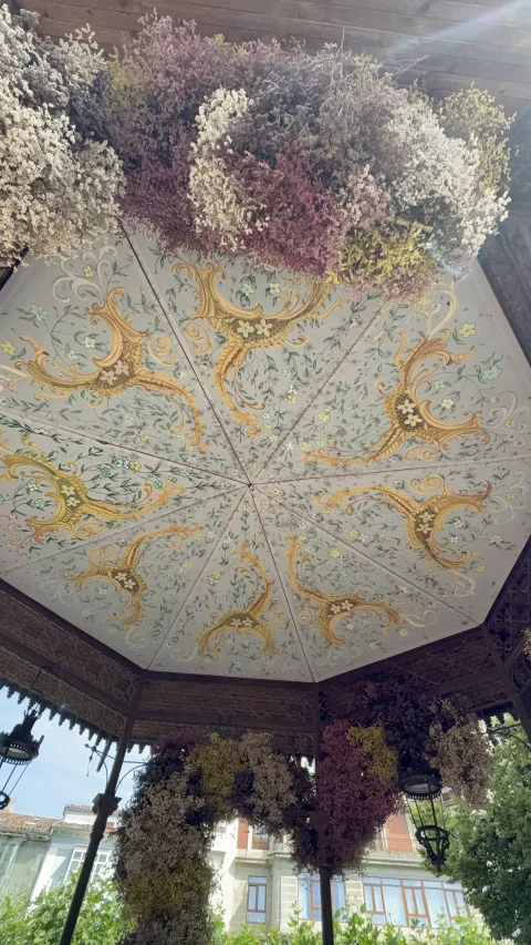 Techo de templete con pinturas florales en paneles triangulares enmarcado por guirnaldas de flores secas