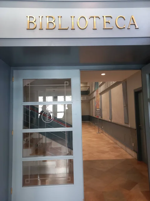 Puerta interior de acceso con vidriera y letrero dorado en relieve de la Biblioteca