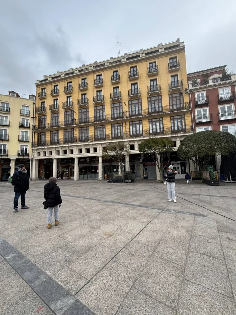 Parte trasera del edificio con fachada porticada de color ocre en la Plaza Mayor