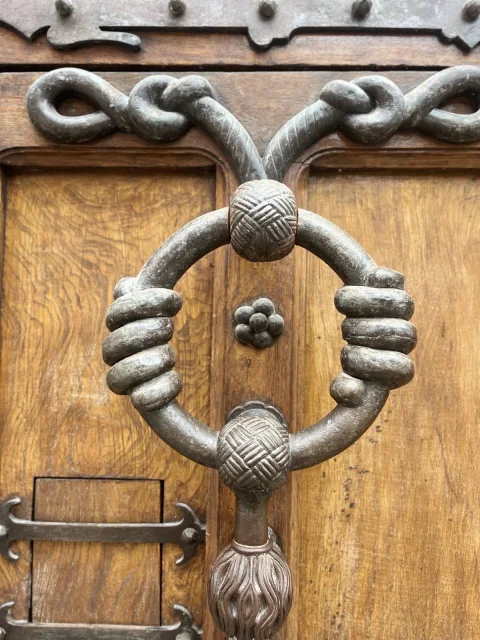 Detalle en primer plano del aldabón o llamador de forja de la puerta de entrada