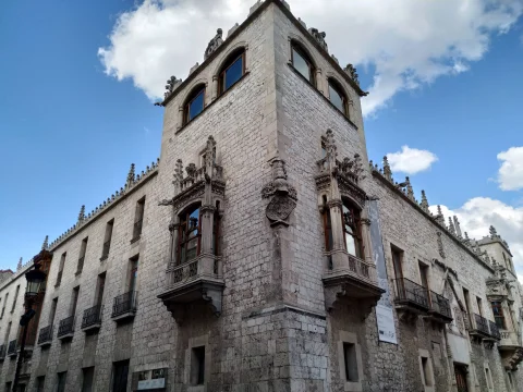 Perspectiva contrapicada de la torre señorial que destaca los balcones volados ricamente labrados, la crestería gótica superior