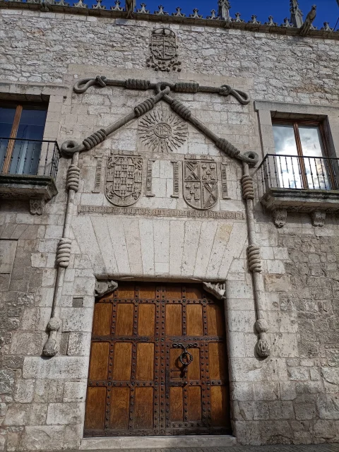 Vista frontal completa de la portada con el cordón franciscano enmarcando las armas de Don Pedro Velasco y Doña Mencía de Mendoza