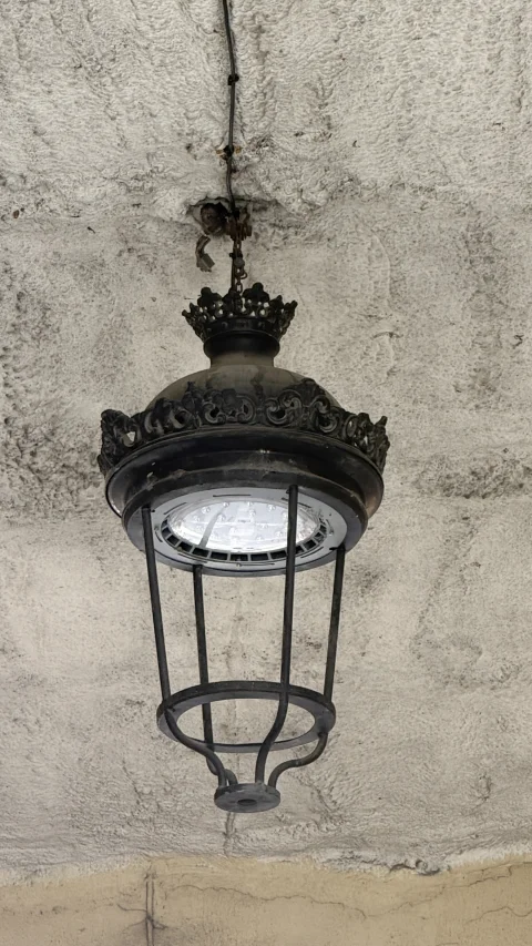 Detalle en primer plano de un farol colgante de hierro fundido