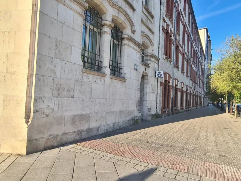 Perspectiva de la calle lateral mostrando los ventanales con rejas de hierro