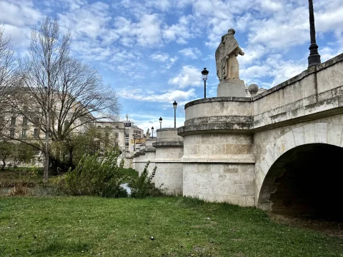 Tajamares semicirculares y arcos de piedra del Puente de San Pablo con estatuas cidianas y cielo nuboso