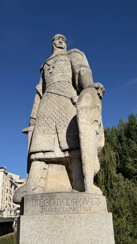 Contrapicado de estatua de piedra de Diego Rodríguez con escudo normando sobre pedestal tallado