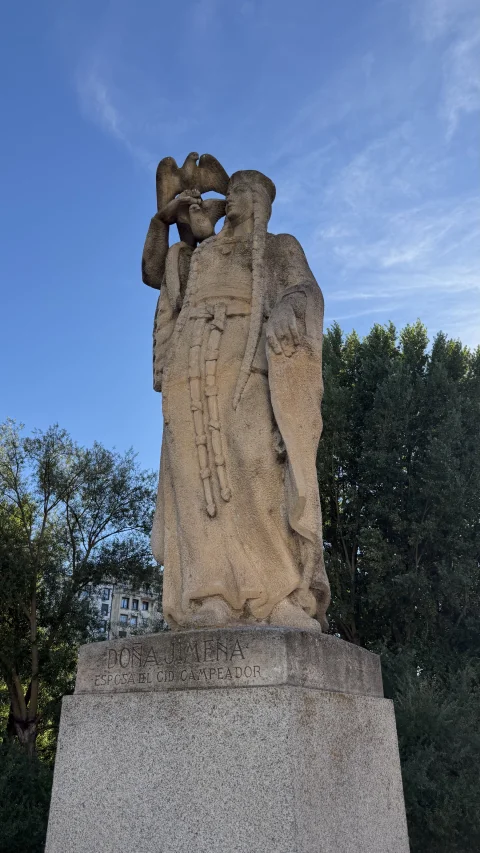 Escultura monumental de piedra tallada de Doña Jimena de cuerpo entero sobre alto pedestal