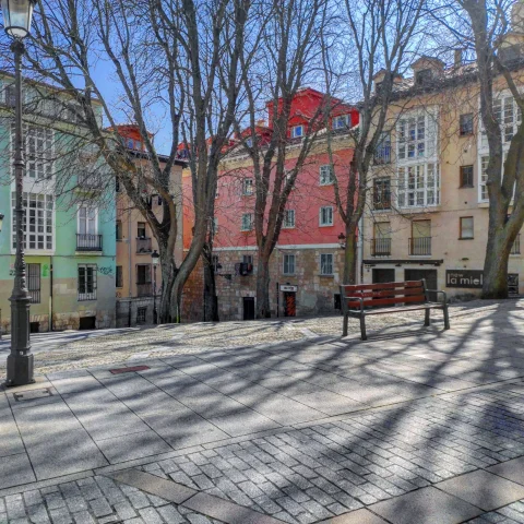 Banco y fachadas de colores en la Plaza de los Castaños