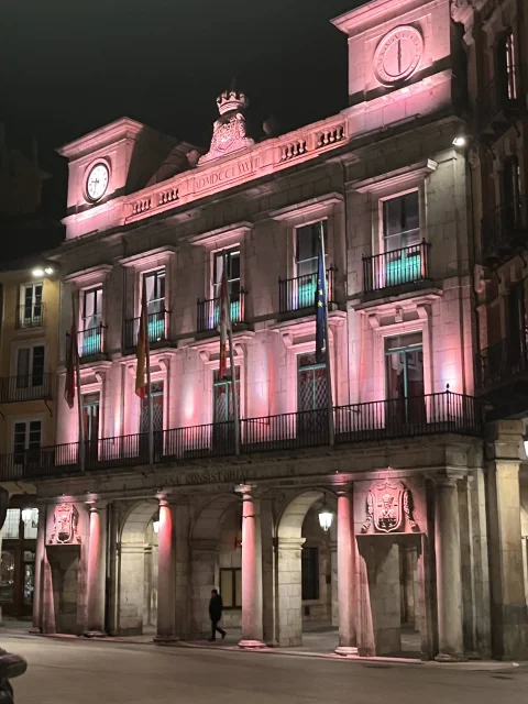 Fachada del Ayuntamiento de Burgos con iluminación ornamental nocturna en tonos rosas