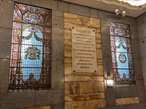 Placa conmemorativa a Alfonso XII y vidrieras en la escalera principal