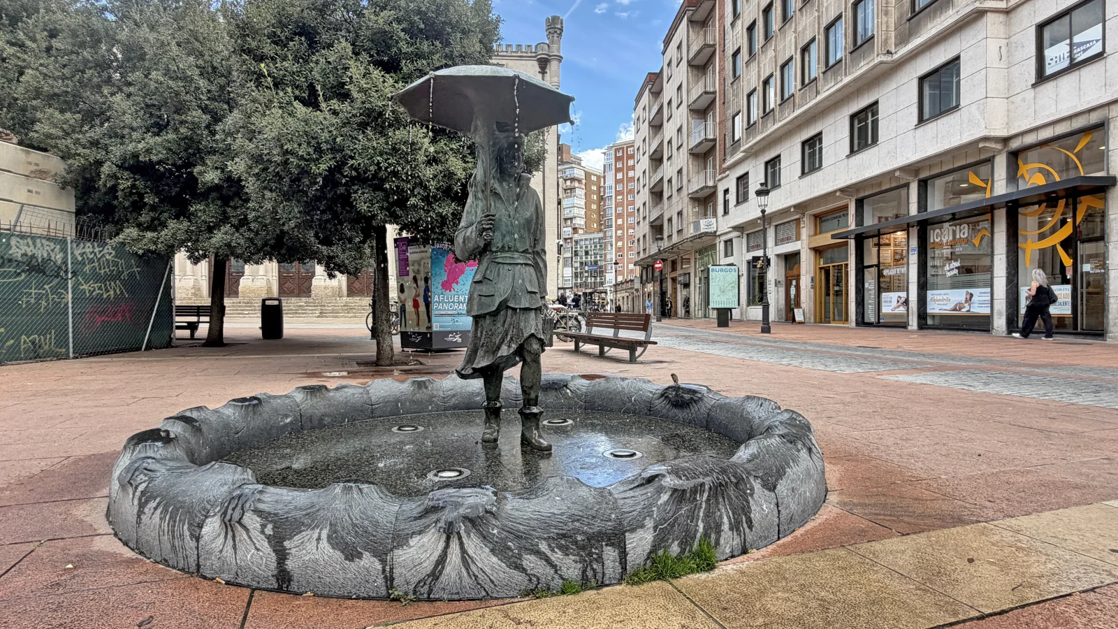 Fuente de la Mujer con Paraguas de Burgos, con el pilón circular y la plaza de Alonso Martínez