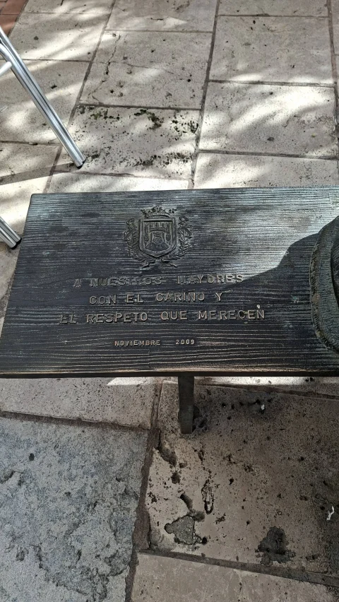 Placa de los Abuelos sentados de Burgos con el escudo de la ciudad y la dedicatoria a nuestros mayores