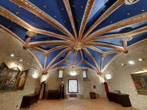 Vista frontal de la capilla con techo estrellado azul y trajes de época