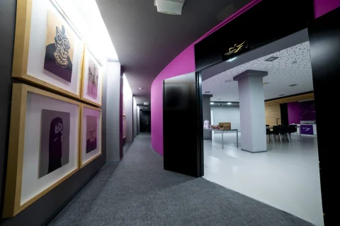 Zona interior moderna que conecta áreas expositivas con espacios para talleres o catering