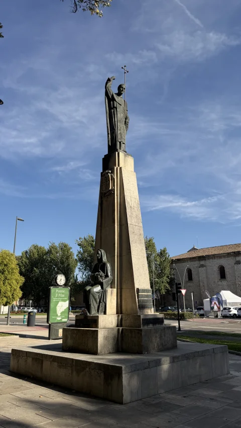 Perspectiva del monumento elevado en la plaza con la estatua dominica en la parte superior