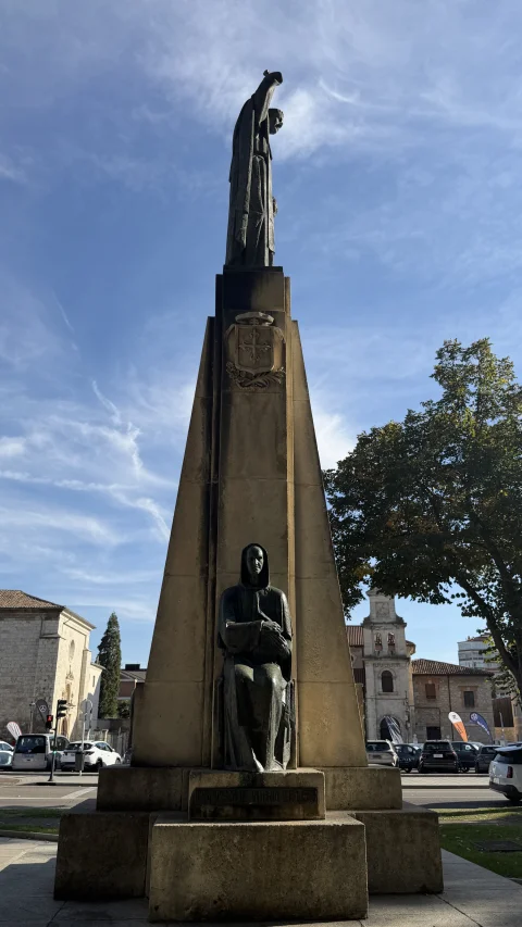 Plano vertical del estilizado obelisco de piedra con una escultura sentada en la base