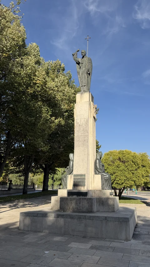 Vista completa del monumento de piedra con la estatua de Santo Domingo en la cima