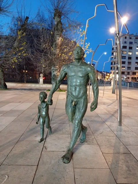 Las figuras de Evolución iluminadas al anochecer