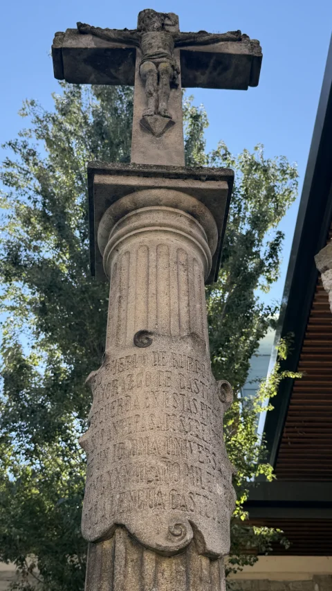 La inscripción tallada en la cartela con volutas del fuste del crucero, muy erosionada