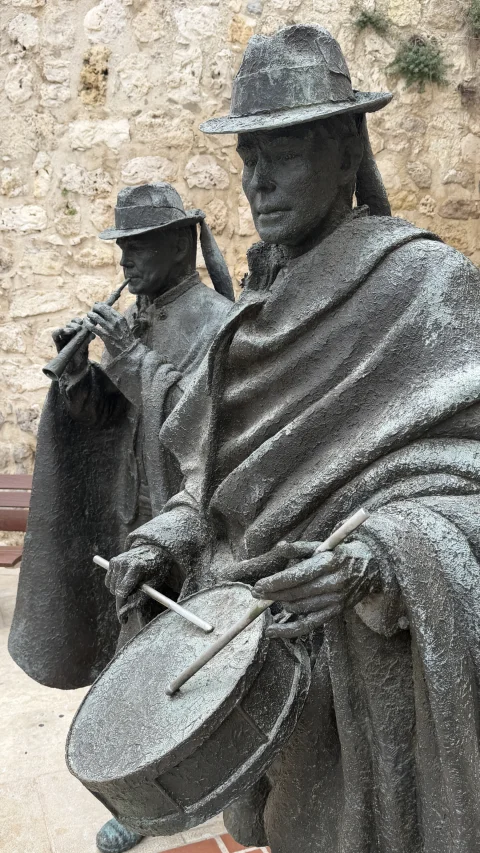 Capas con esclavina y sombreros en la Escultura de Los Dulzaineros de Burgos