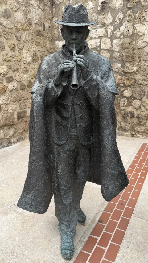 El dulzainero de la Escultura de Los Dulzaineros de Burgos tocando con las dos manos