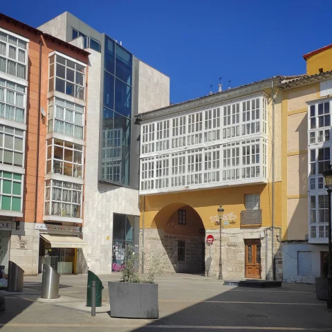 Fachada exterior amarilla con mirador o galería acristalada blanca