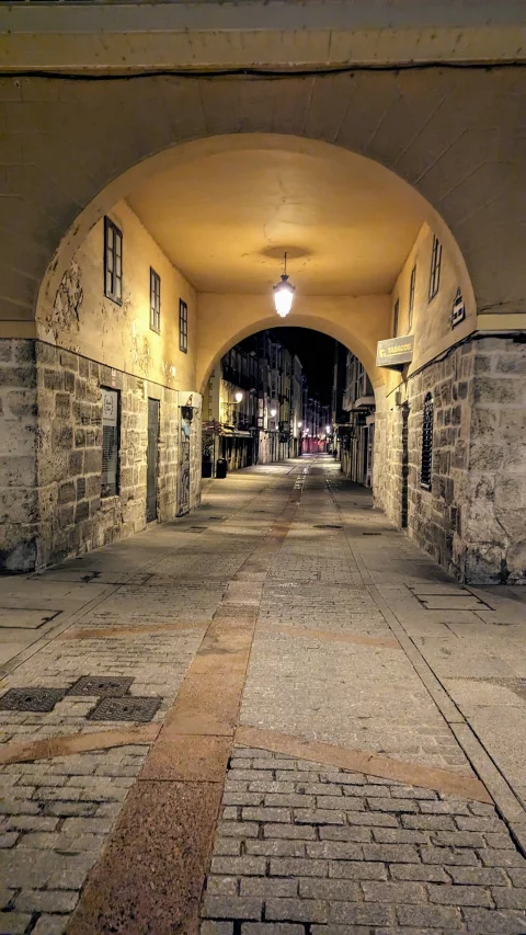 Vista nocturna a través del pasadizo abovedado del Arco de San Juan
