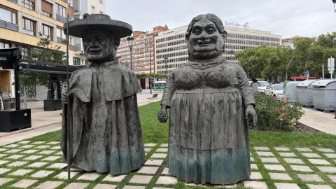 Escultura de Los Gigantillos de Burgos entre los rosales de la plataforma peatonal