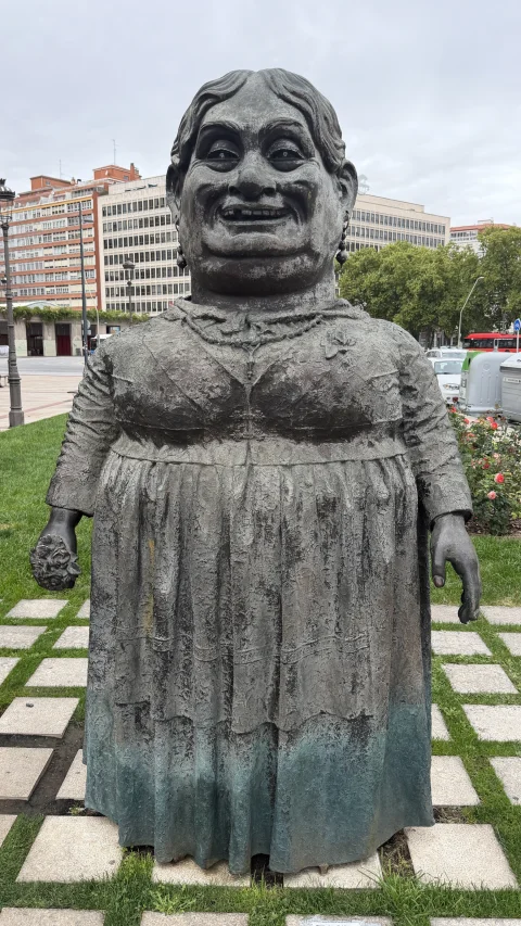 Figura femenina de la Escultura de Los Gigantillos de Burgos con pendientes, collar y ramo de flores