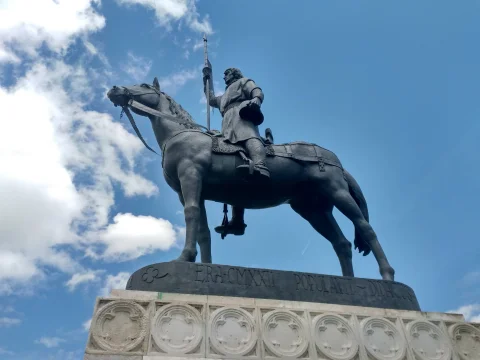 Estatua ecuestre de Diego Porcelos de perfil sobre su pedestal de piedra ornamentado