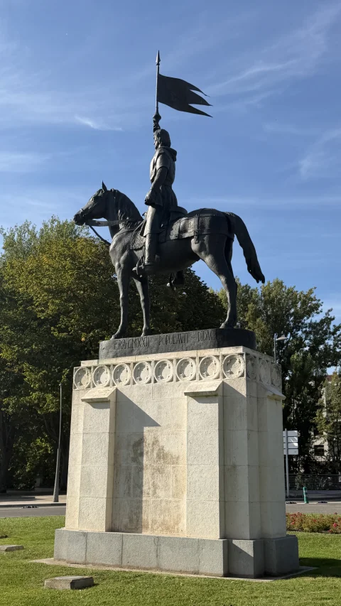 Vista de perfil del monumento a Diego Porcelos a caballo con el pendón ondeando en la parte superior