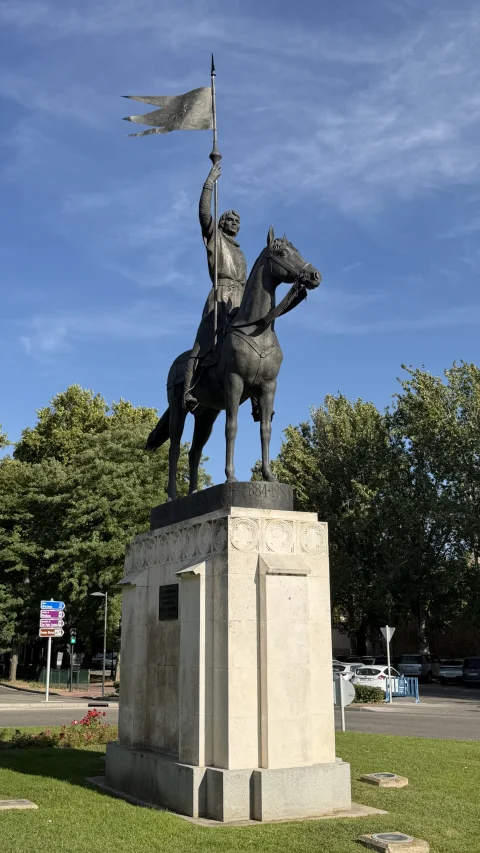 Vista en perspectiva de la estatua ecuestre de Diego Porcelos mirando hacia adelante sobre su pedestal
