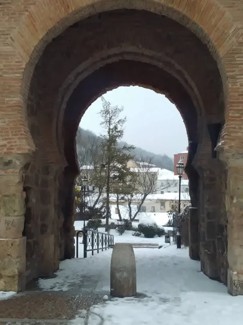 Arco de San Esteban nevado con vista hacia el parque exterior