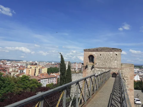 Camino de ronda o adarve de la muralla con barandilla metálica conducido hacia la torre defensiva