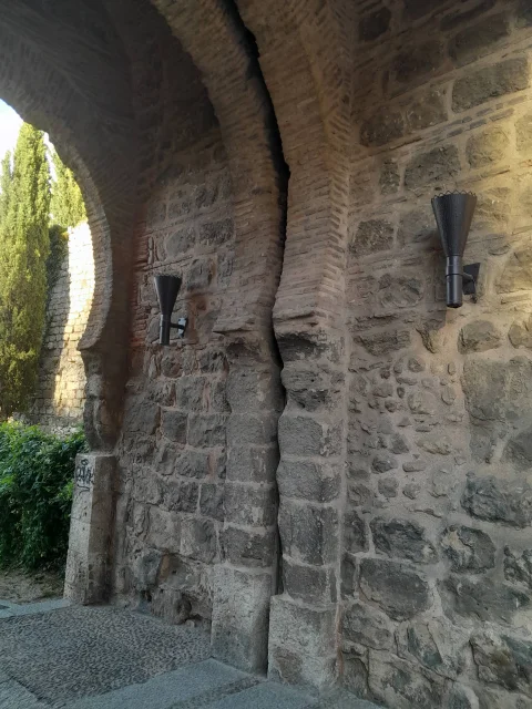 Detalle del pasadizo interior del arco con apliques de iluminación de estilo antorcha